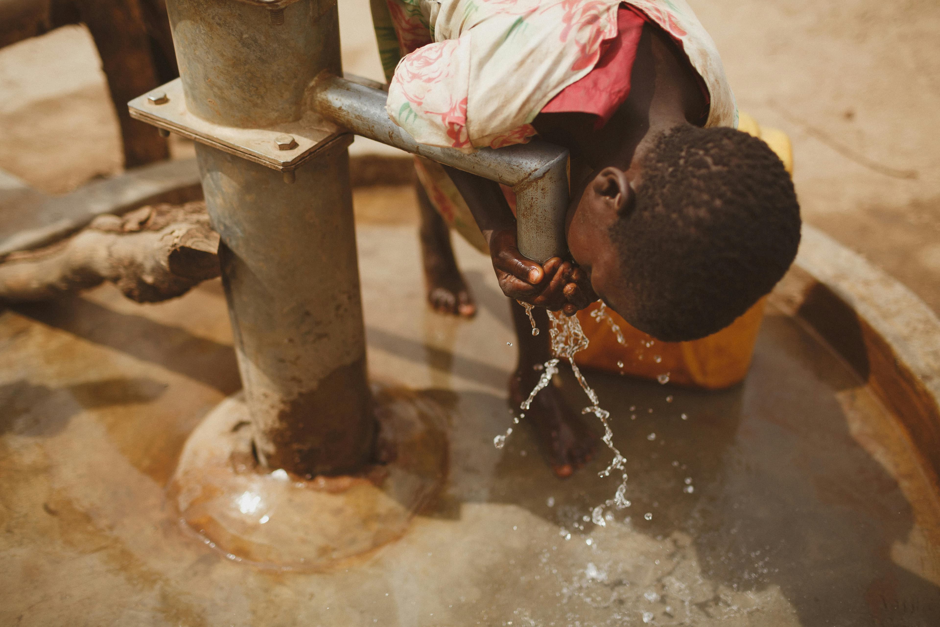 a child drinking from a borehole